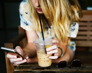 A woman drinking a coffee, one of the most relevant products for the UK loyalty industry. 